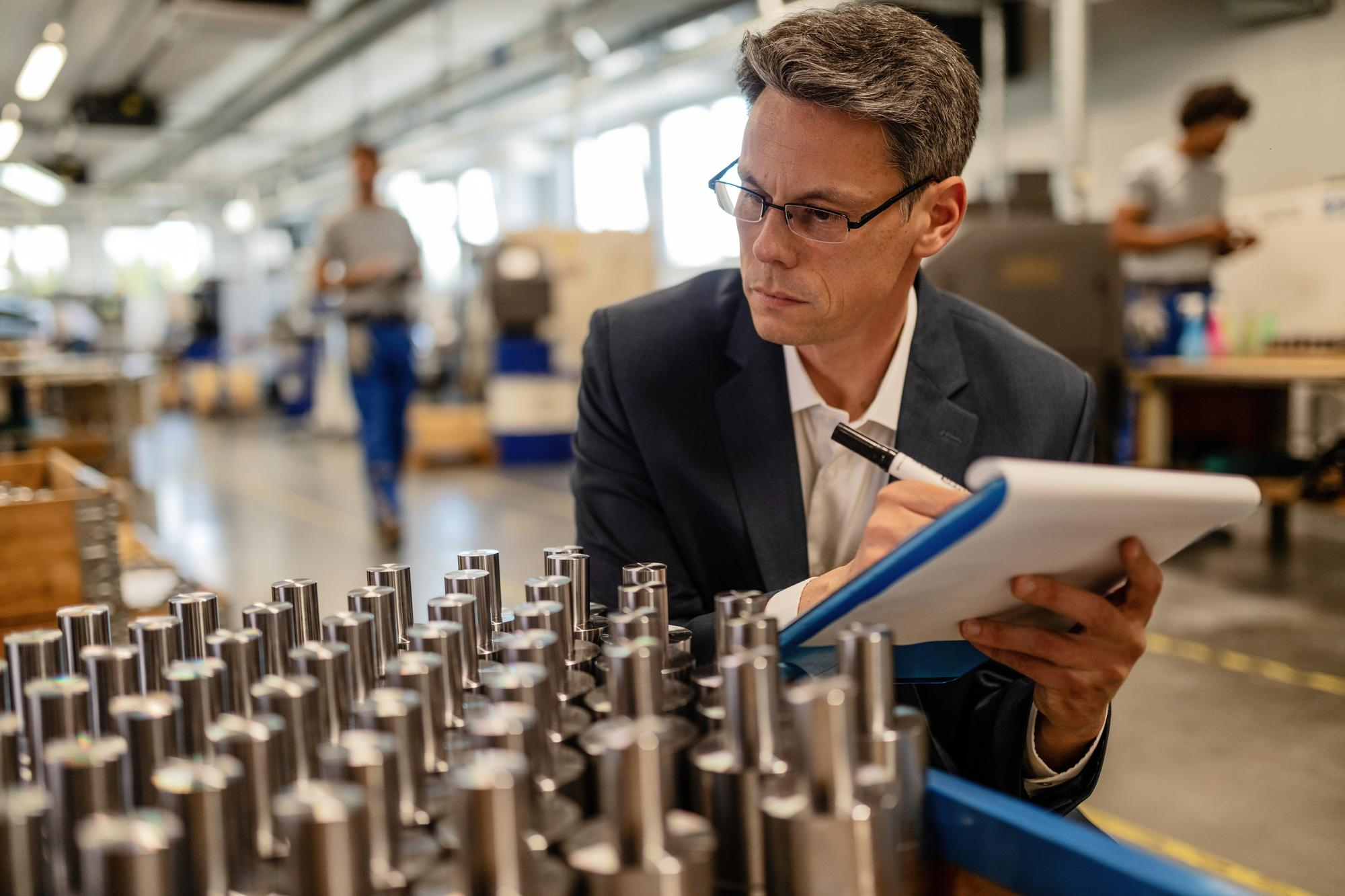 Hombre realizando inspección visual obligado por el sistema de calidad implantado en la empresa.