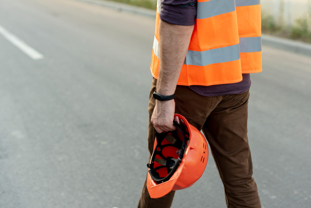 Trabajador con casco en la mano.