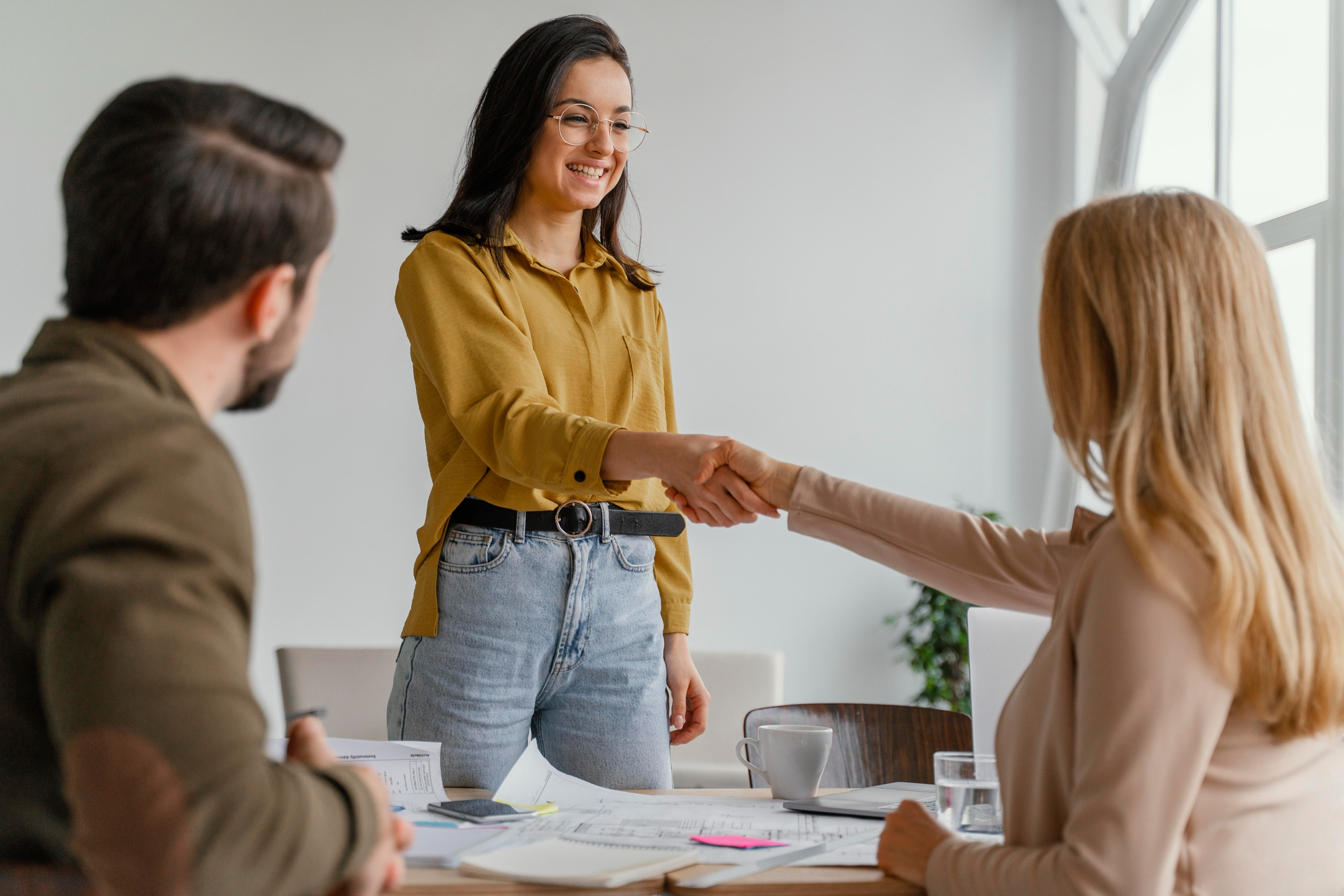 Mujeres estrechándose las manos en señal de negociación concluida.