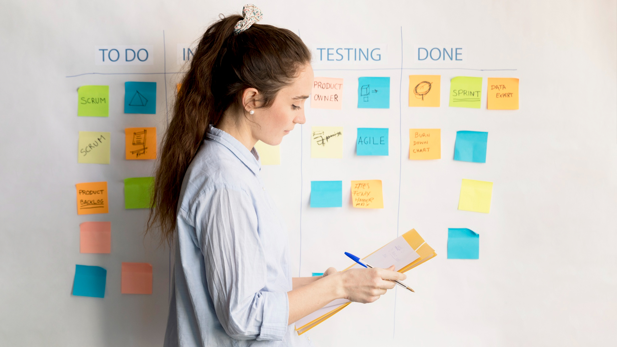 Mujer trabajando en una pizarra con tecnología SCRUM