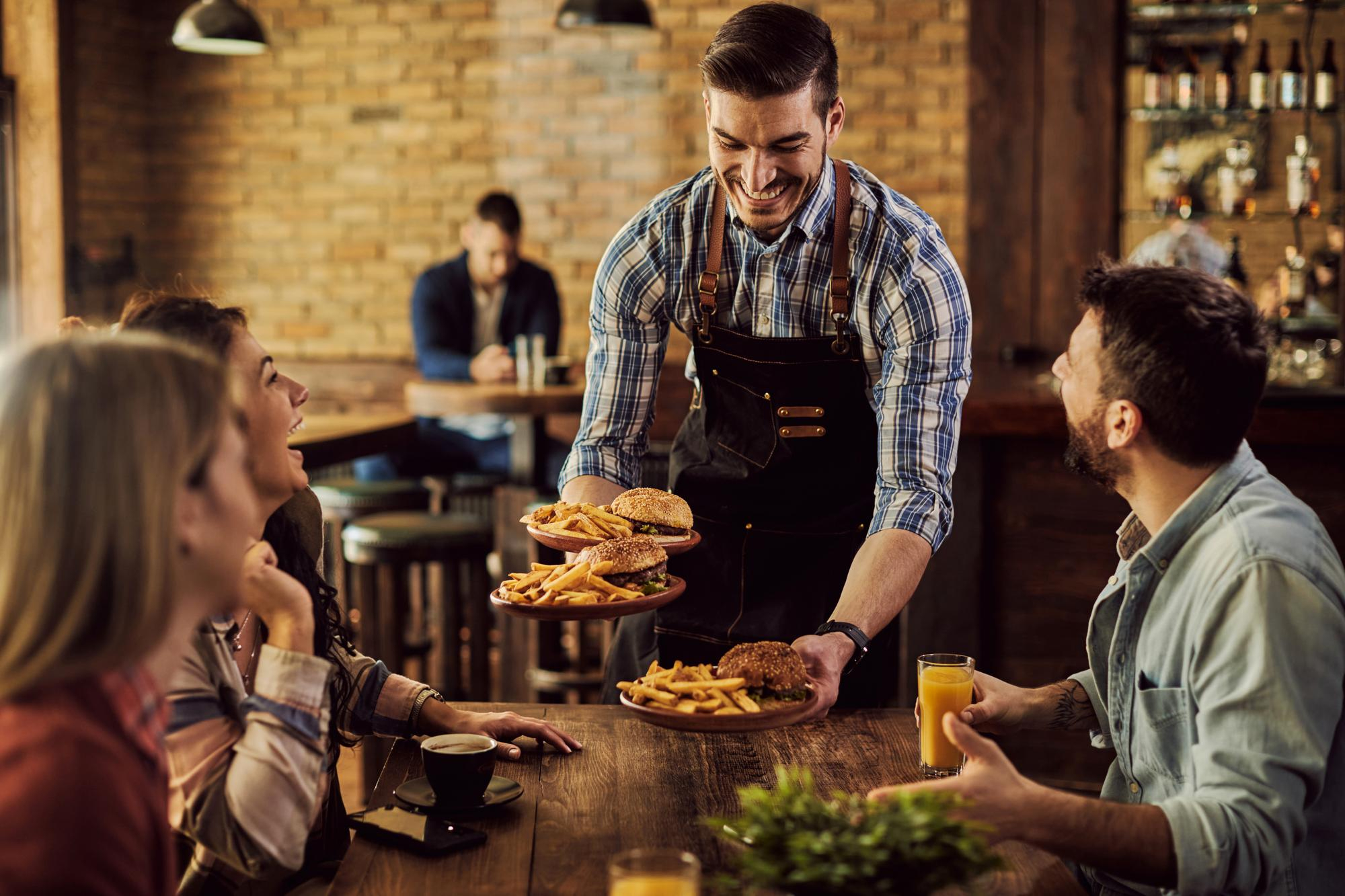Joven español trabajando de camarero en un restaurante de Irlanda gracias al programa EURES